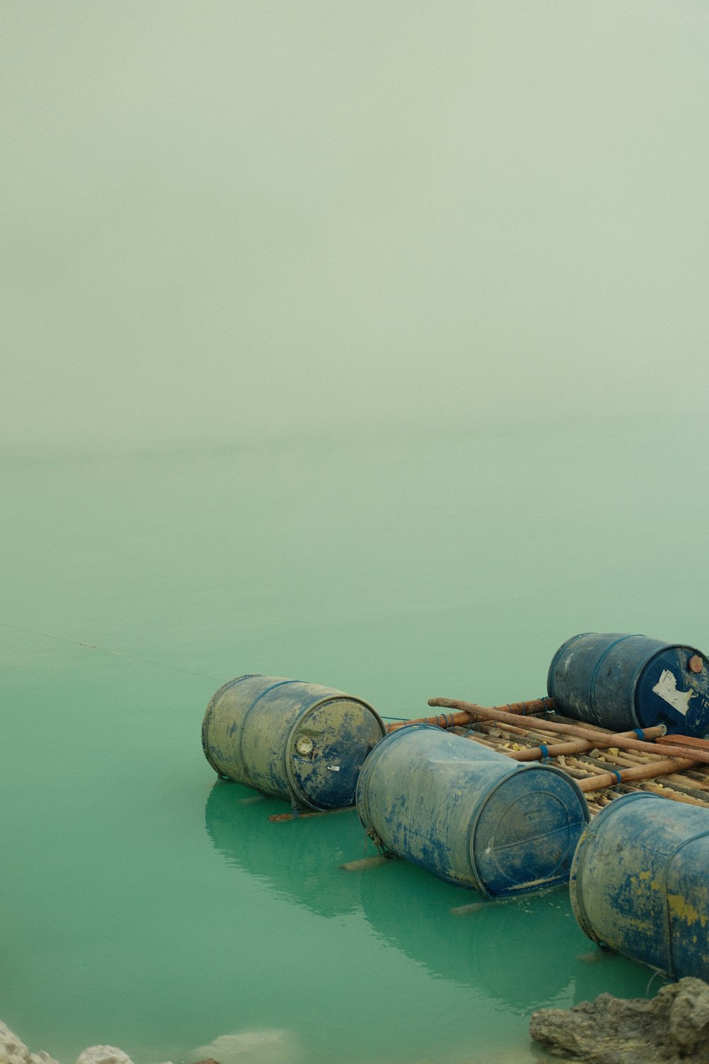 a group of barrels sitting on top of a body of water