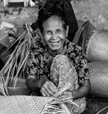 Smiling hands weaving colorful baskets as part of a skill-building workshop.