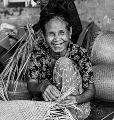 A group of smiling participants weaving reclaimed fabric into baskets.