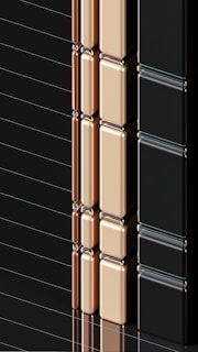 A series of glossy, rectangular tiles arranged vertically with a metallic finish. The tiles are colored in gold, copper, and black, creating a sleek and modern appearance. The surface reflects light, highlighting the smooth texture and polished edges.