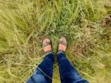 Side view of feet in joppa espadrilles stepping on soft grass