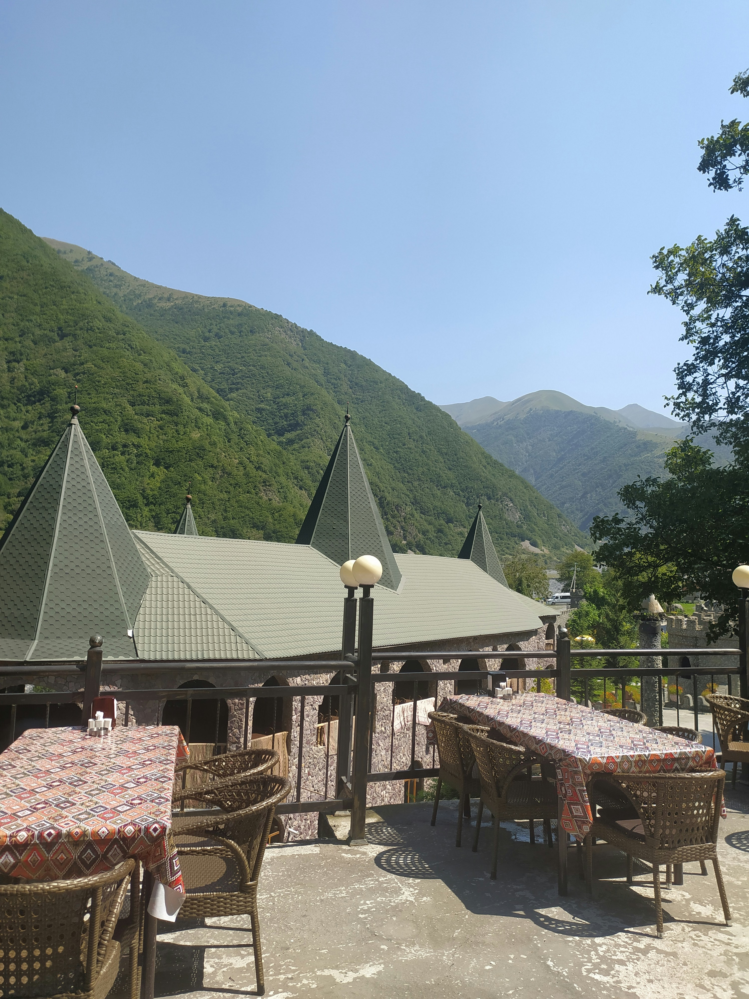 Outdoor terrace with rustic chairs overlooking pine trees in Da Lat