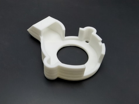 A sleek prototype model of an industrial component freshly printed in white resin.