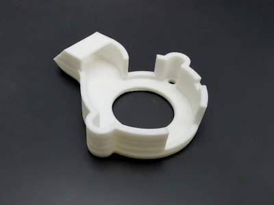 Close-up of a 3D-printed flexible accessory with intricate patterns, casting soft shadows