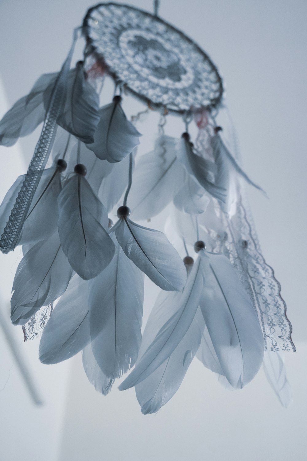 a white dream catcher hanging from a ceiling