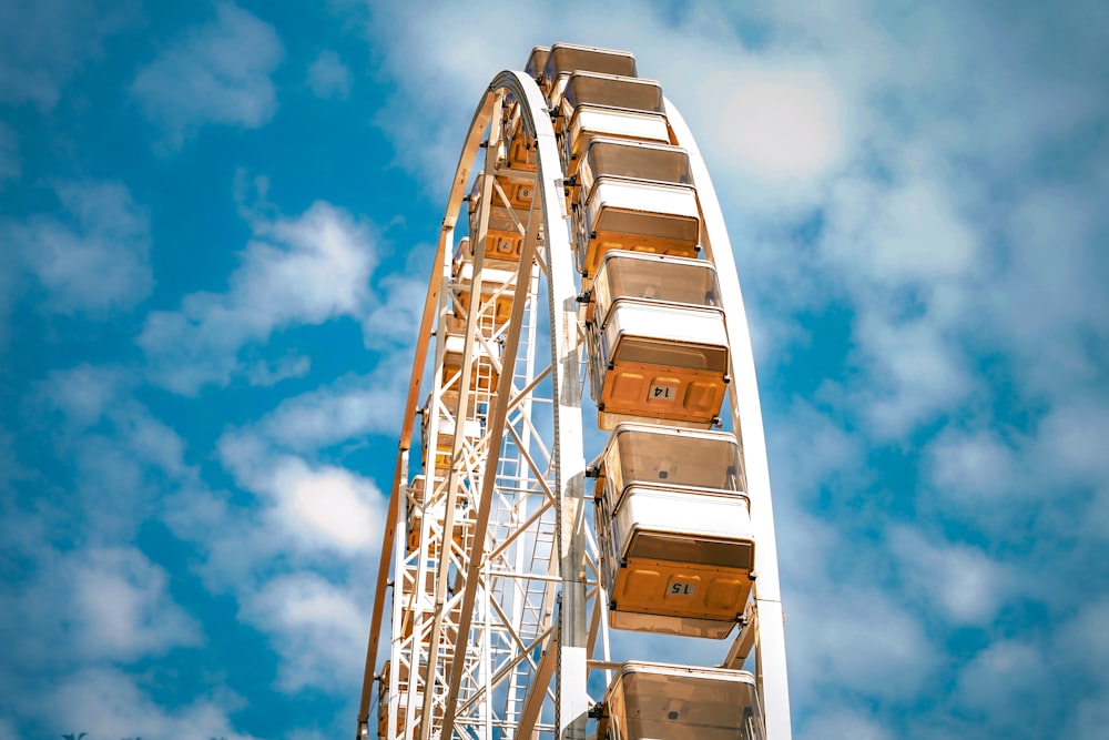 a ferris wheel against a blue sky with clouds