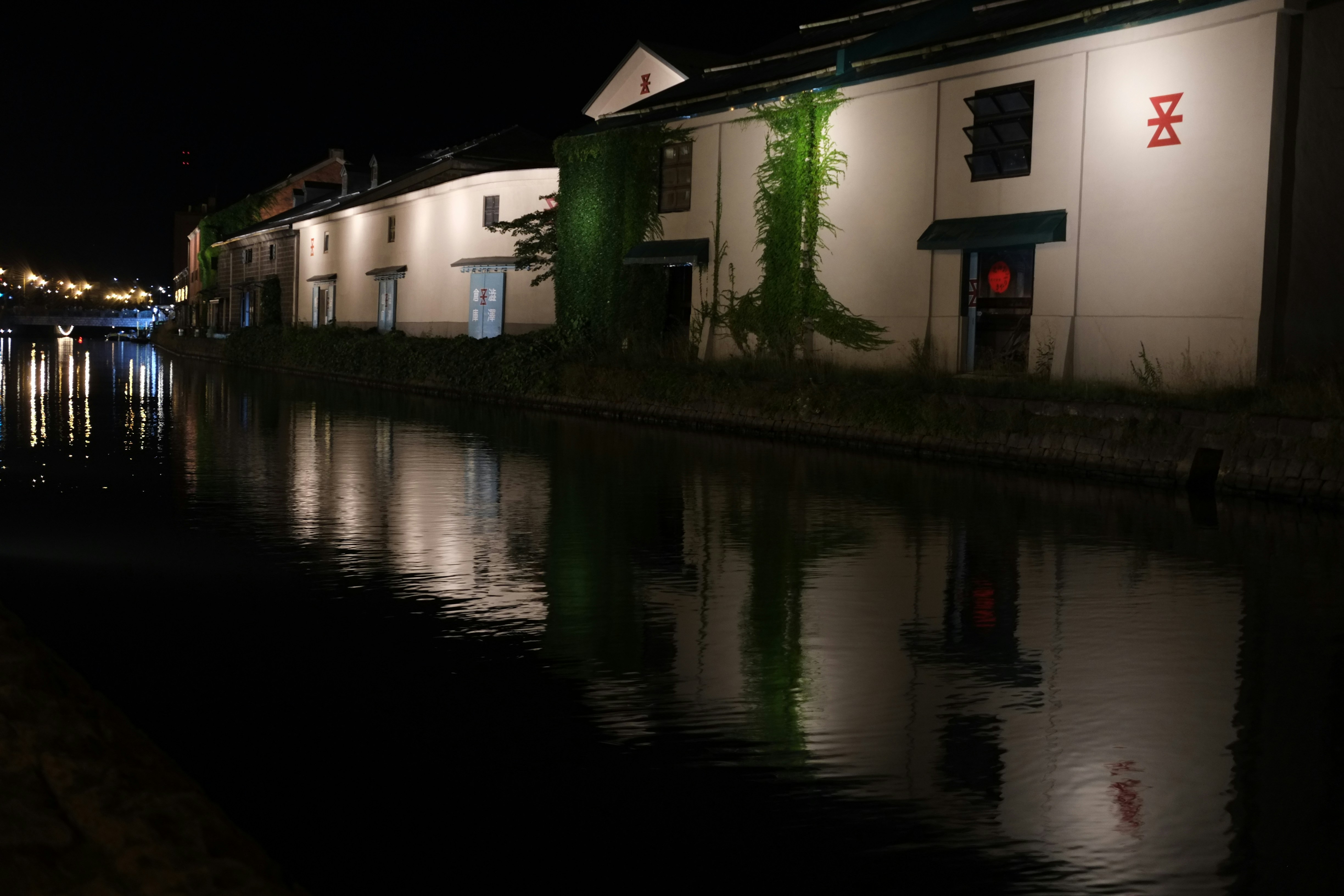 um edifício ao lado de um corpo de água à noite