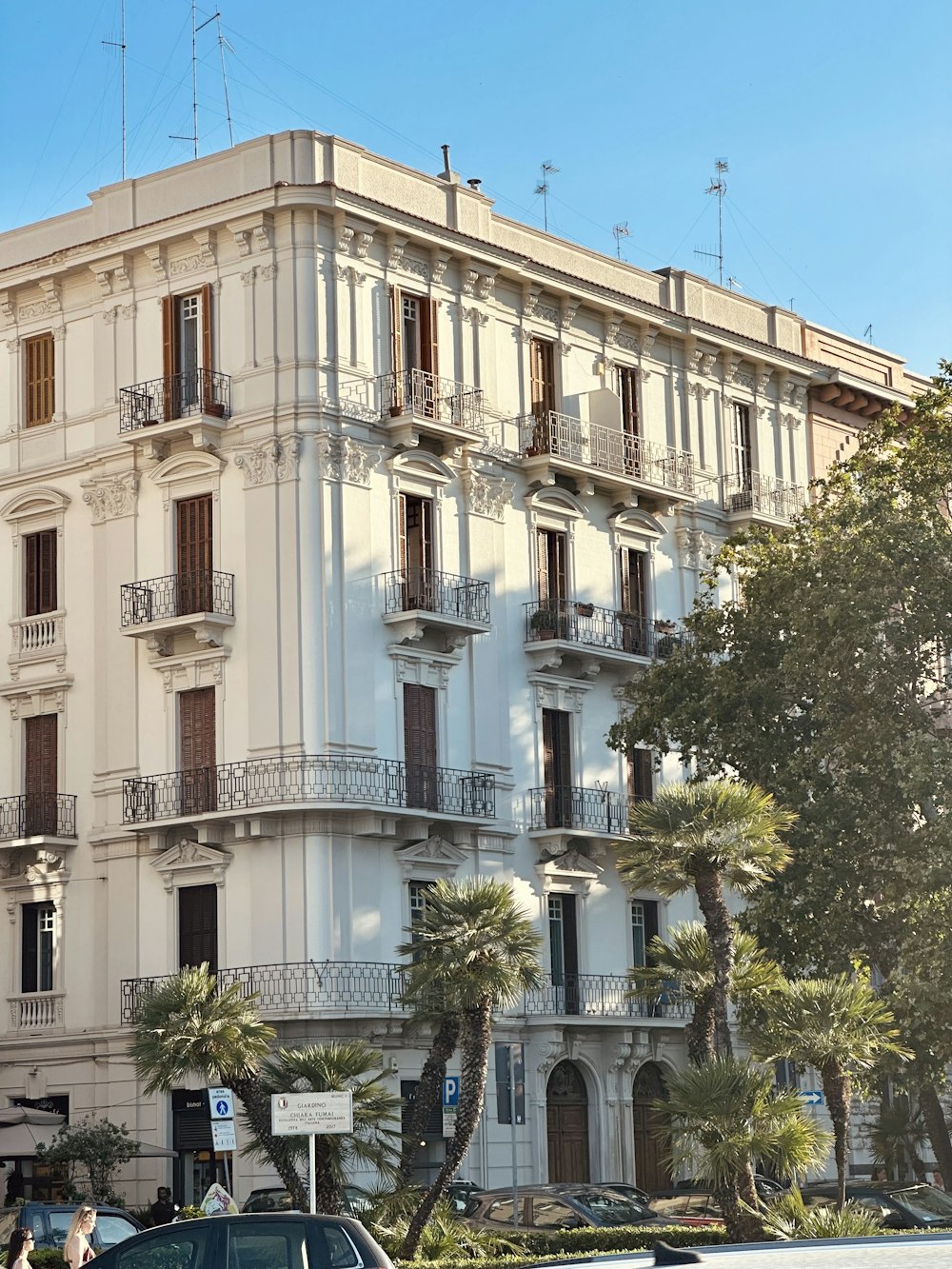 un'auto parcheggiata di fronte a un alto edificio bianco