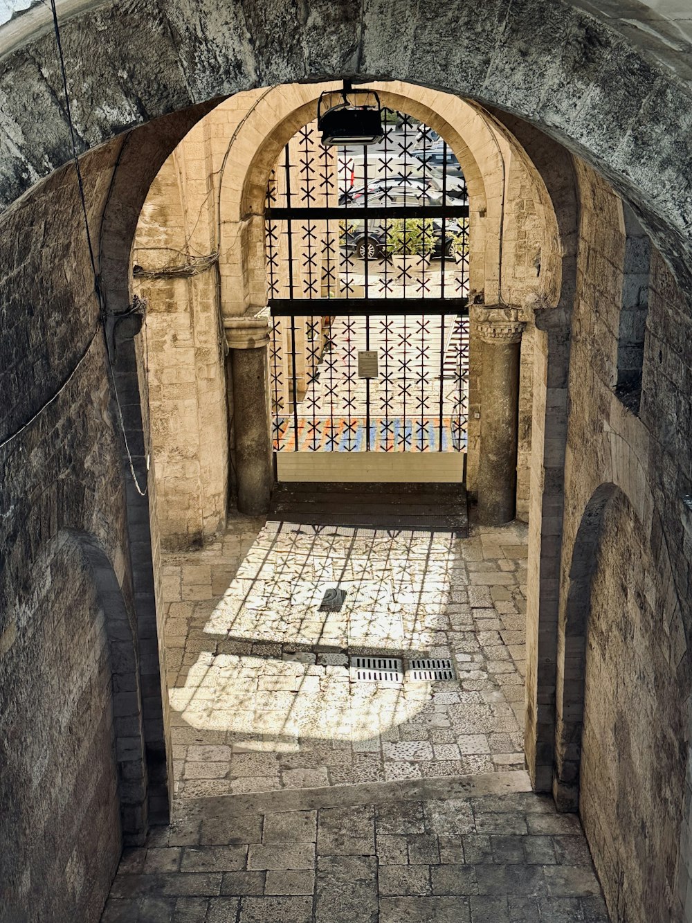 a stone archway with iron bars and a window