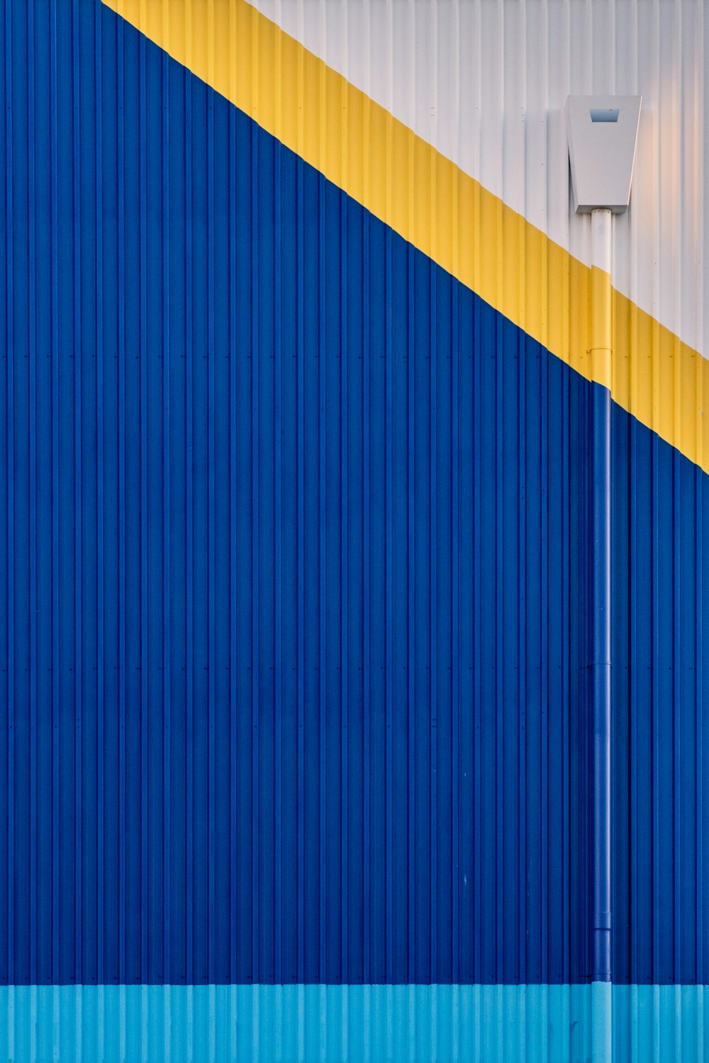 a blue and yellow wall with a street light