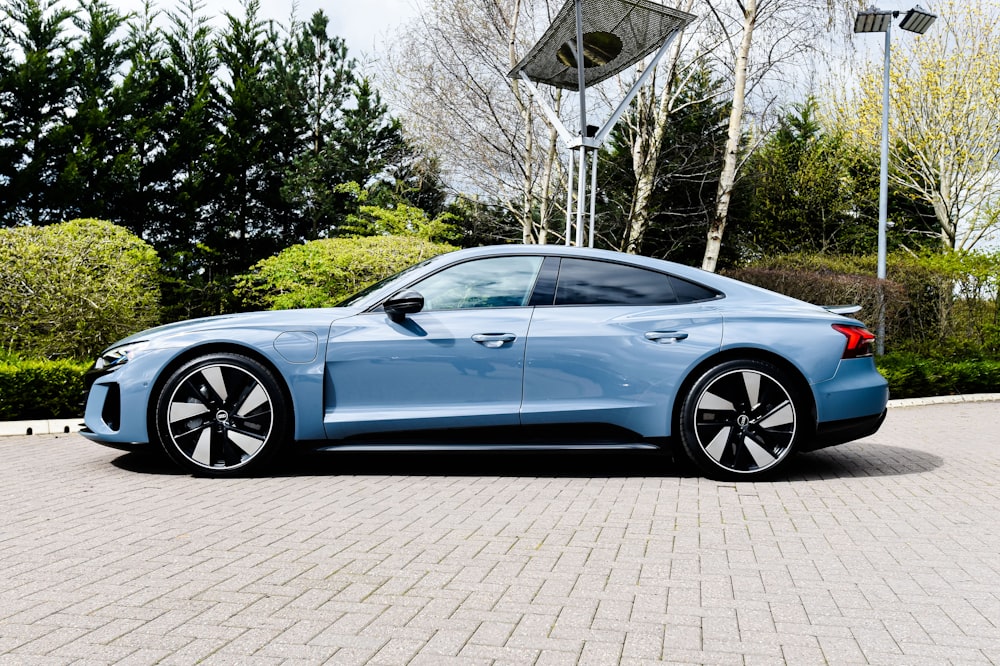 a blue car parked on a brick road