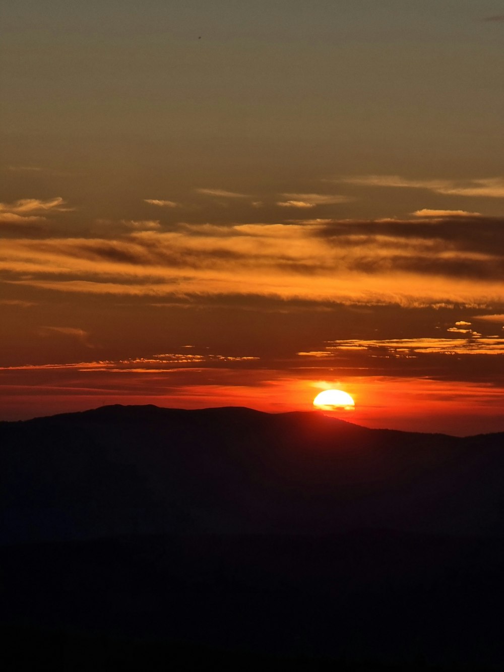 Il sole sta tramontando su una catena montuosa