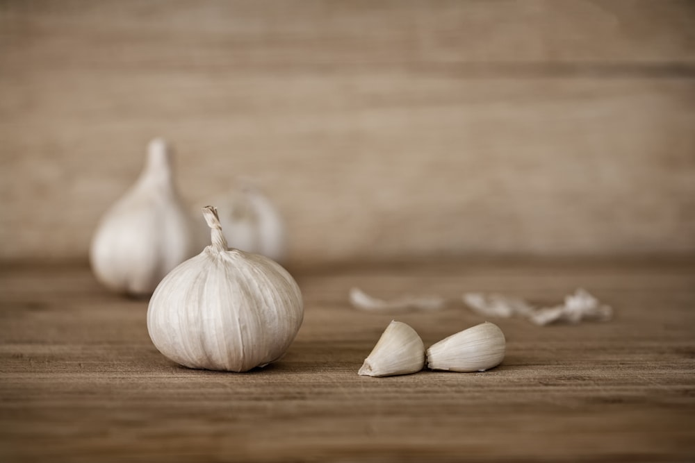 a couple of garlics sitting on top of a wooden table
