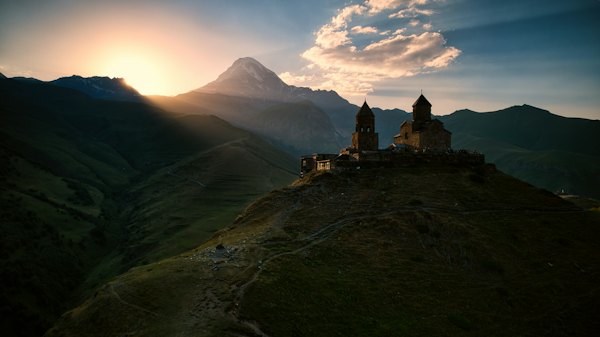 A castle sitting on top of a lush green hillside — Kazbegi, Georgia