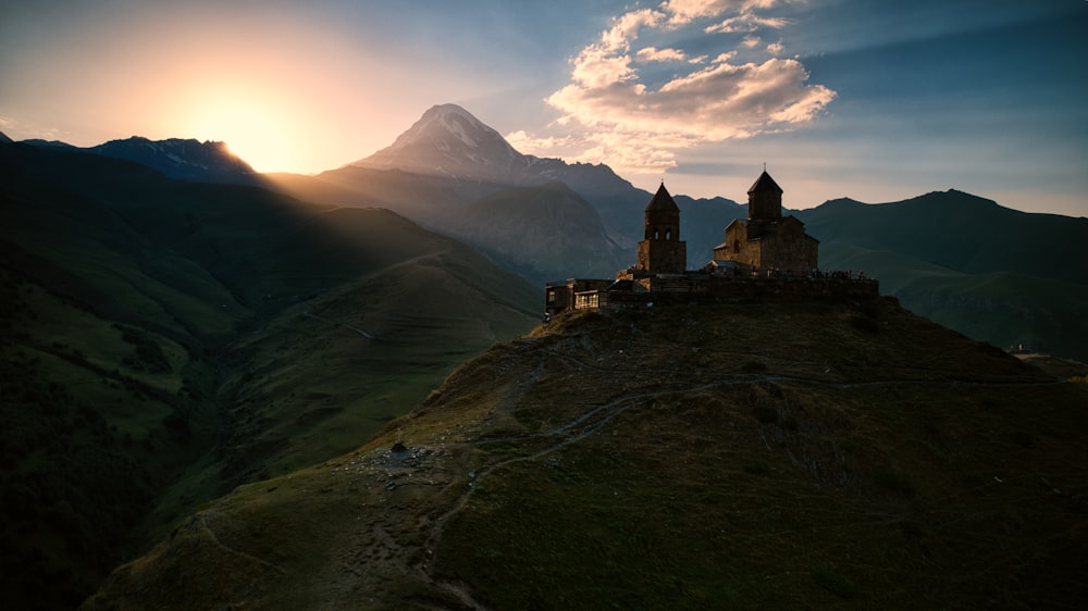 a castle sitting on top of a lush green hillside