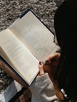 a woman is reading a book on the ground