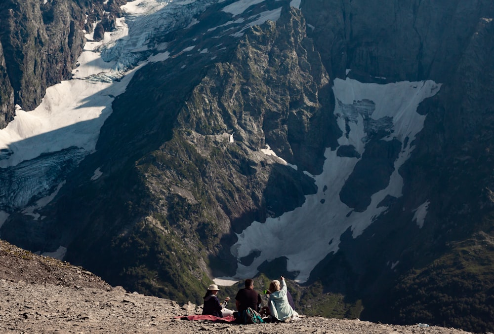 a group of people sitting on top of a mountain