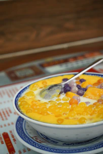 Brightly colored popping boba pearls spilling out of a small bowl onto a rustic table.