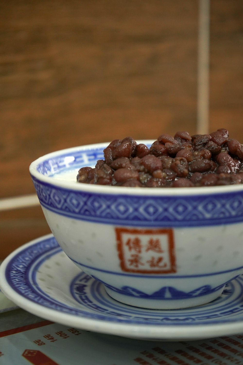 a blue and white bowl filled with beans on top of a table