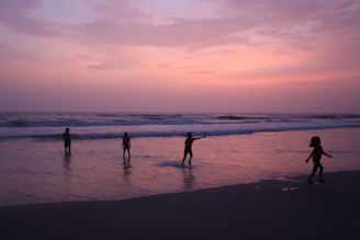 A sunset silhouette of kids playing on a beach, with Core Thrills activity books resting nearby.