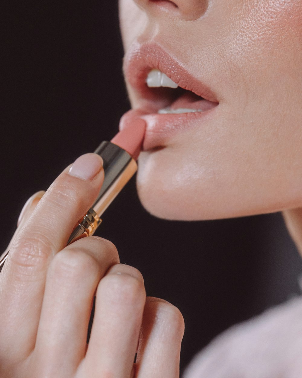 a woman putting lipstick on her lips