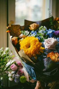 a bouquet of flowers sitting next to a window