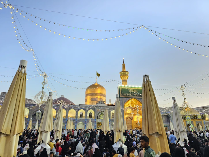 A vibrant community gathering in a Berlin mosque courtyard during a sunny afternoon.