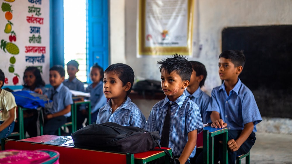 a group of young children sitting in a classroom