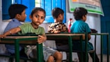a group of young children sitting at a table