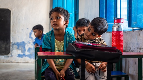 a group of children sitting at a table in a room