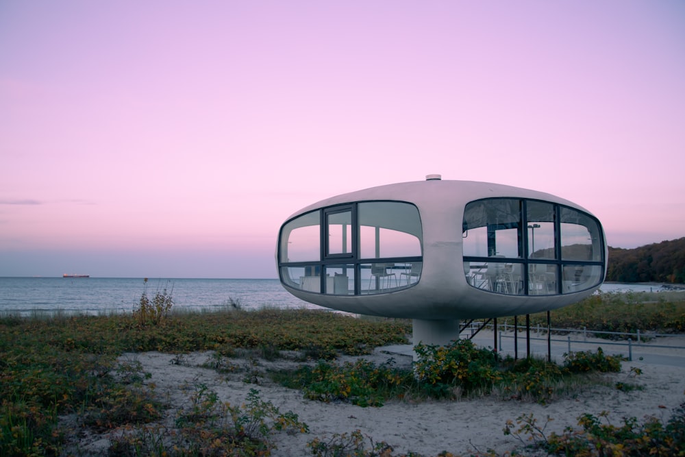 Un edificio blanco con grandes ventanales en una playa