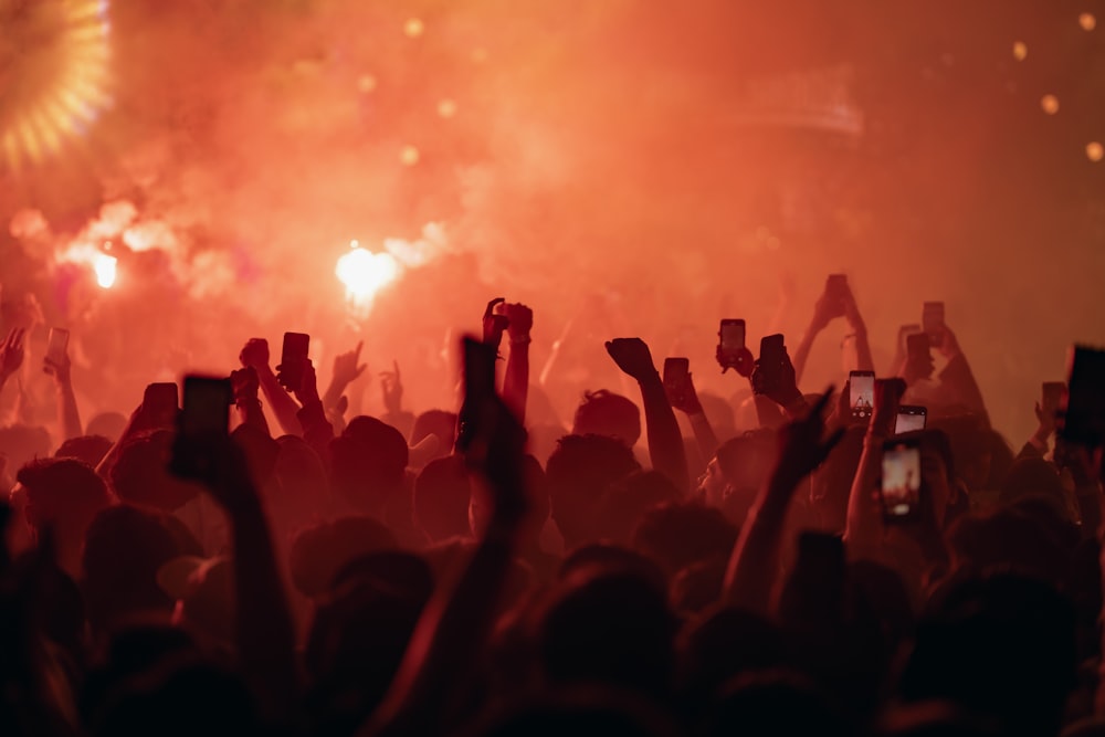 a crowd of people holding up their cell phones