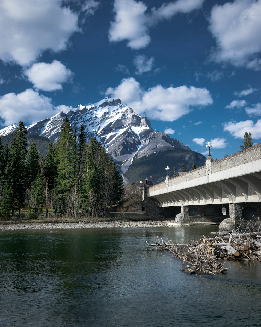 a bridge over a river with a mountain in the background