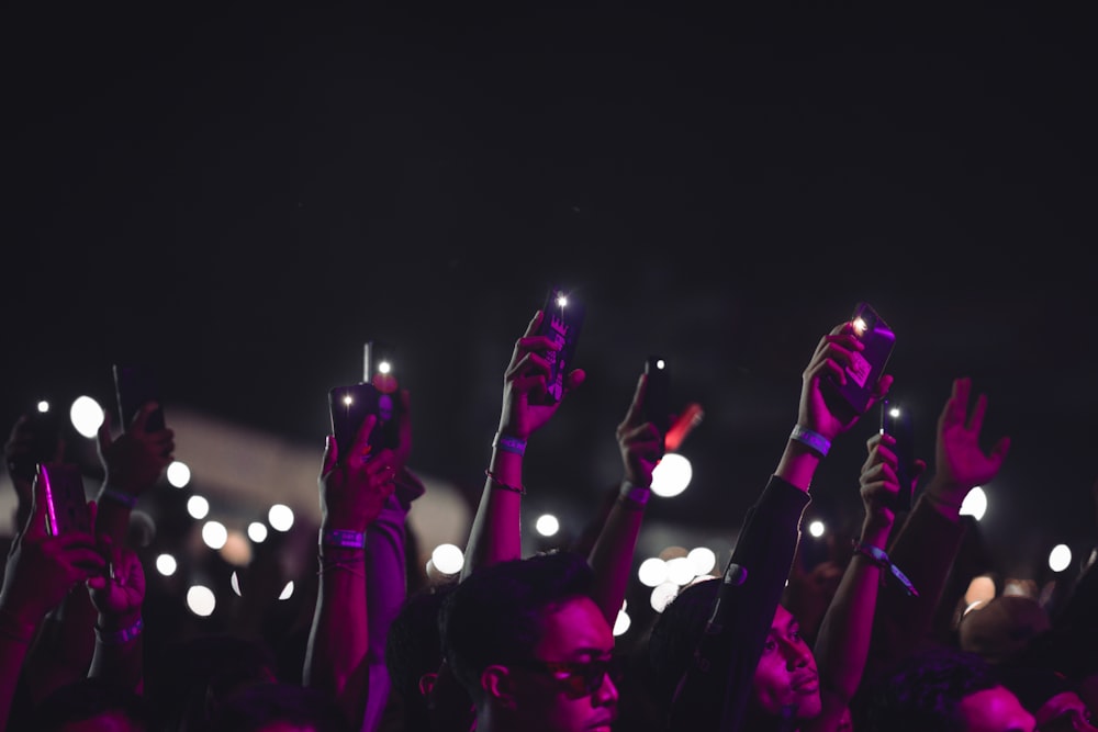 a crowd of people holding up their cell phones