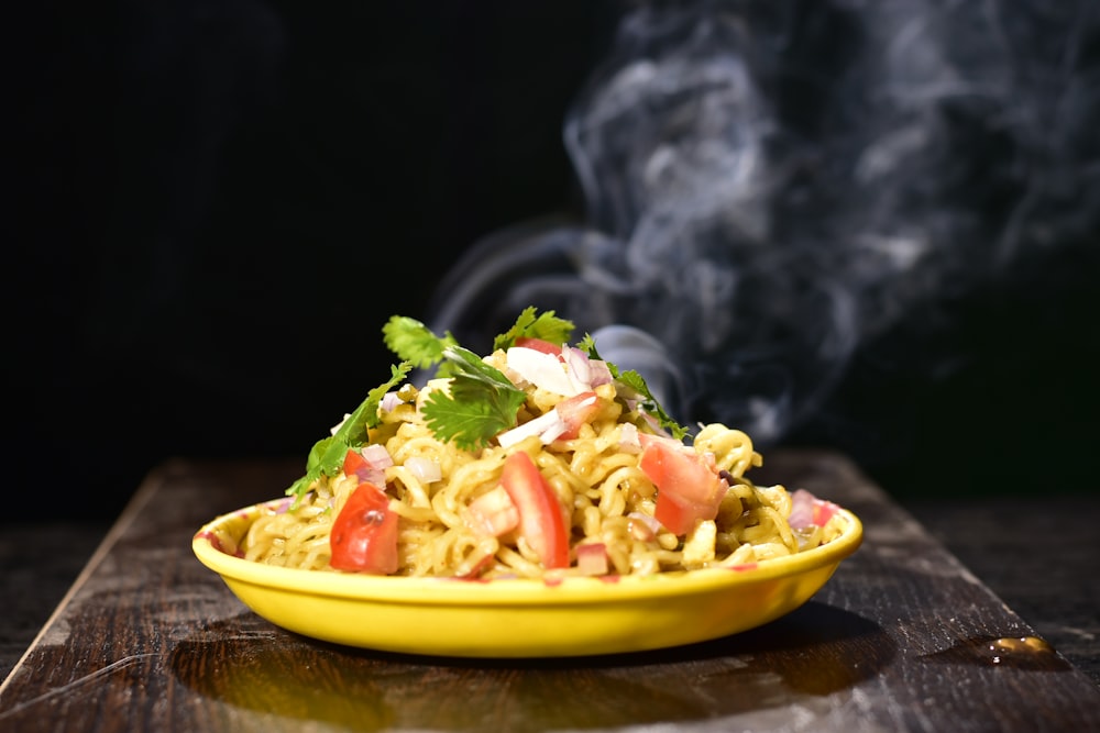 a yellow bowl filled with food on top of a wooden table