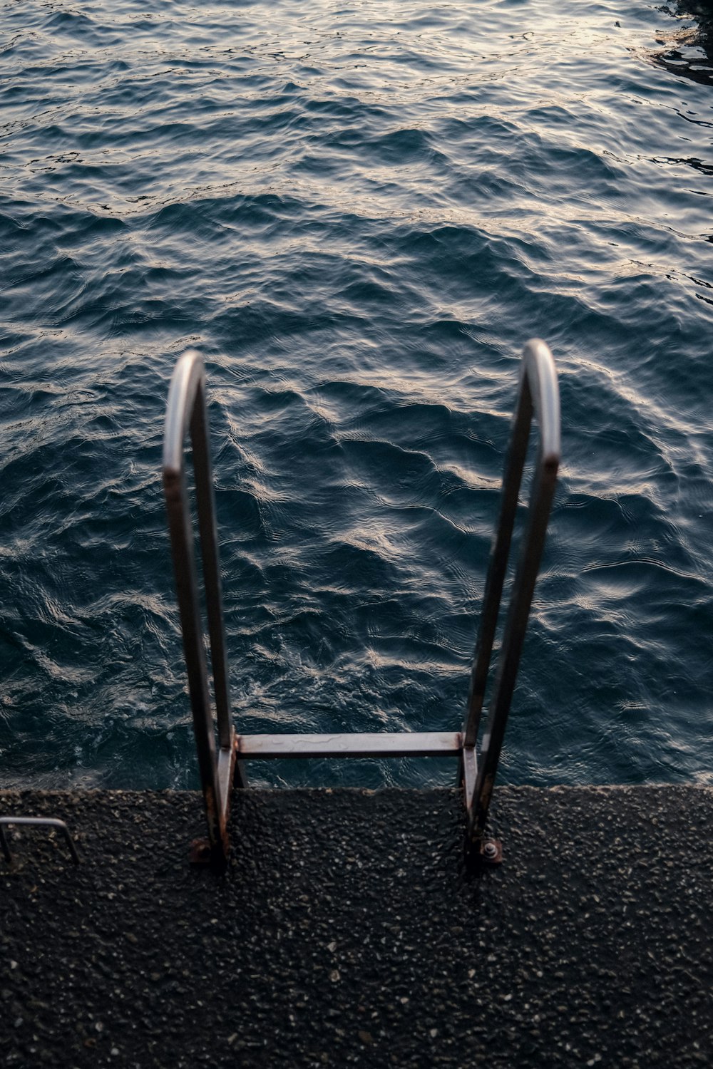 a pair of metal railings next to a body of water