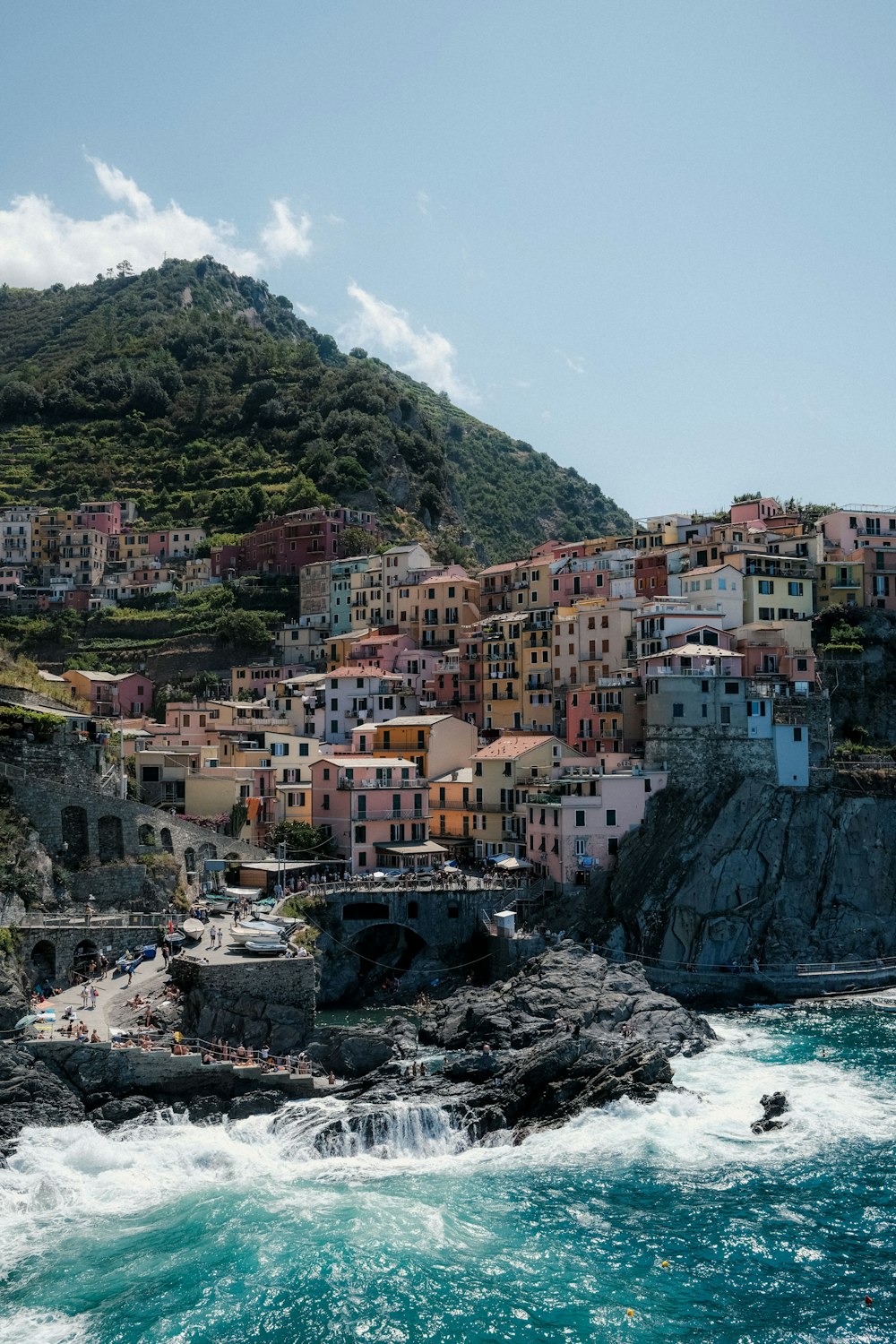 a small village on the side of a cliff next to the ocean