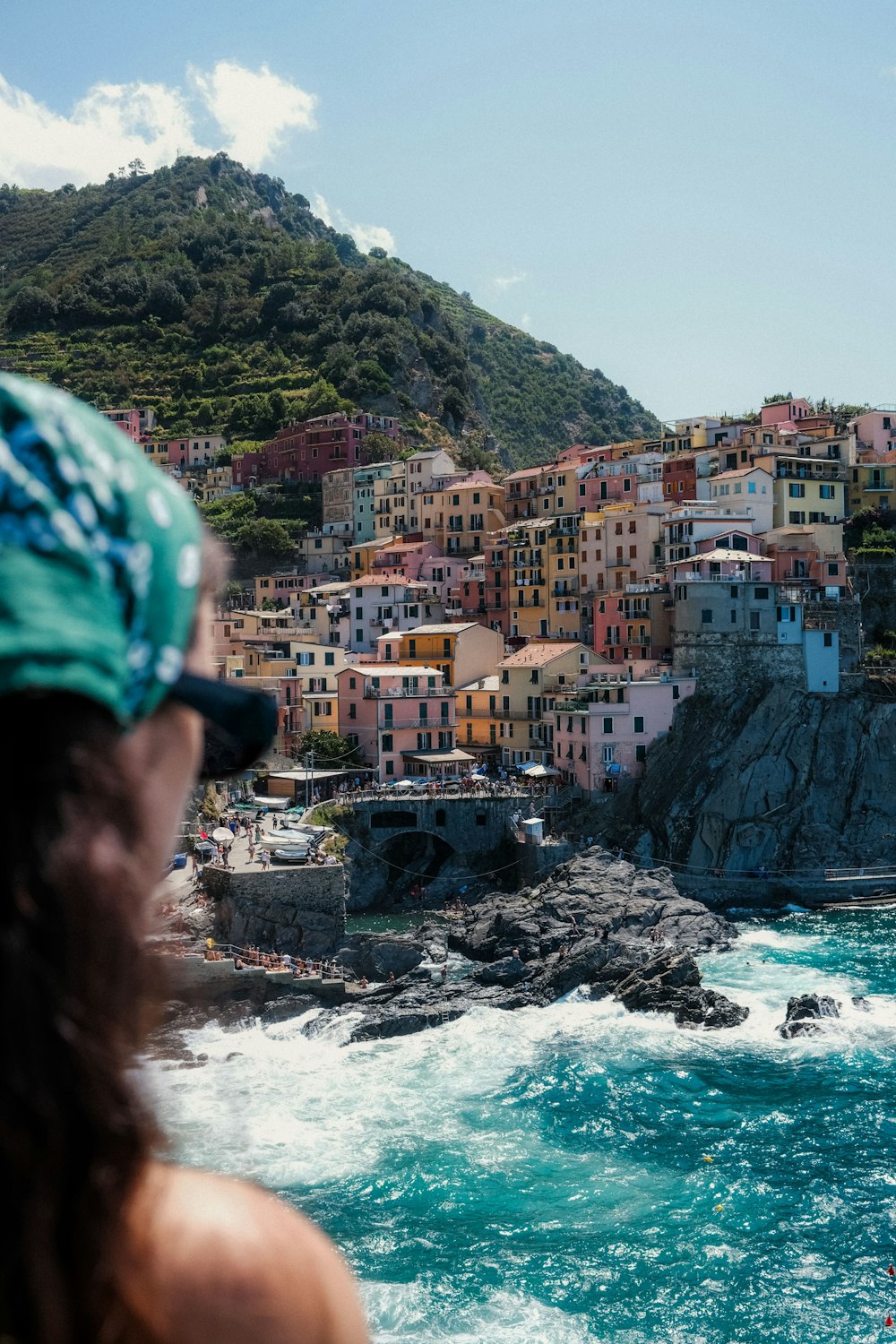 a woman looking at the ocean with a city in the background