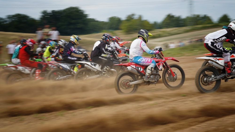 a group of people riding dirt bikes on a dirt road