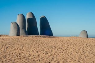 a group of large rocks sitting on top of a sandy beach