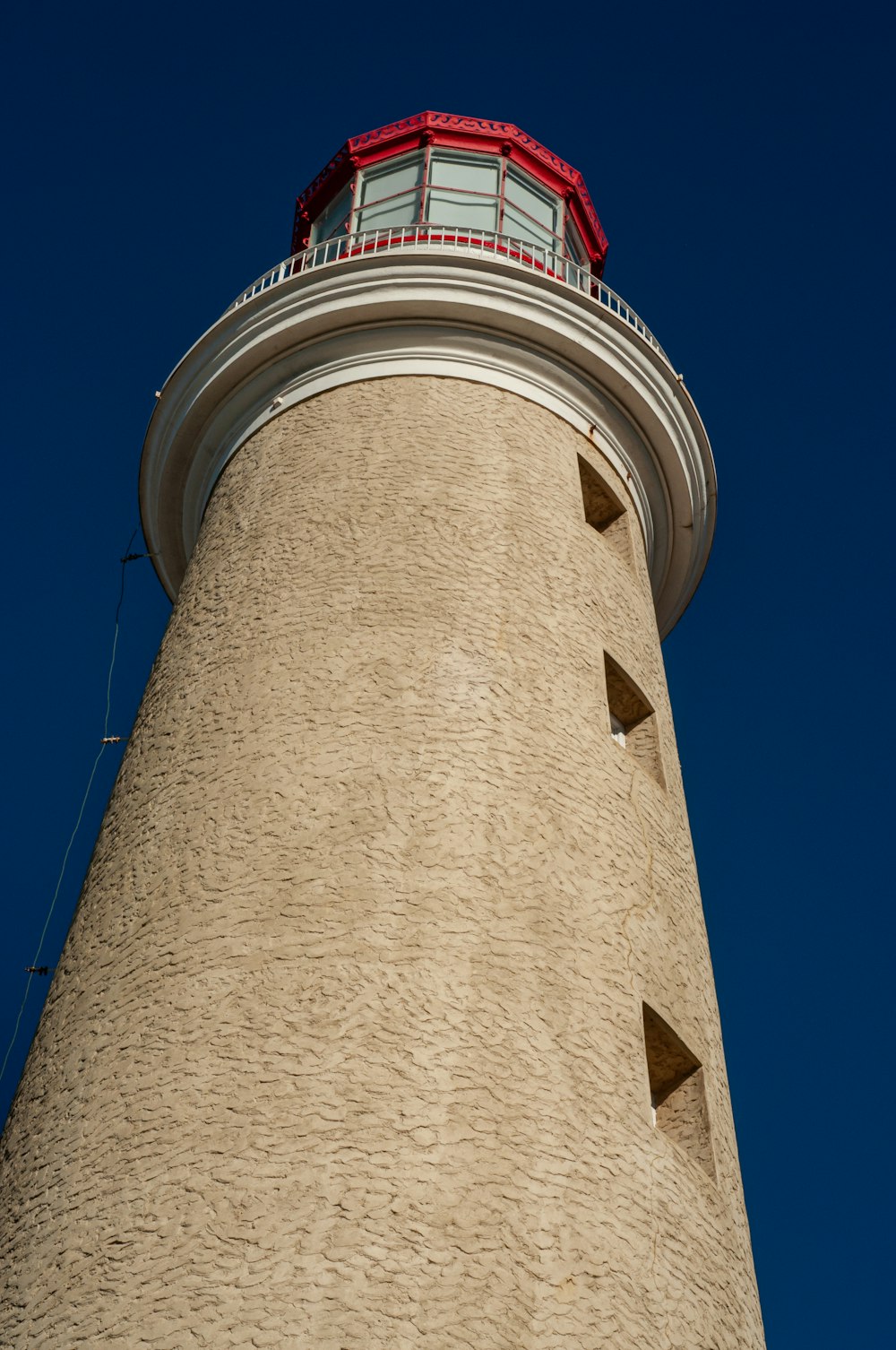 a tall light house with a red roof