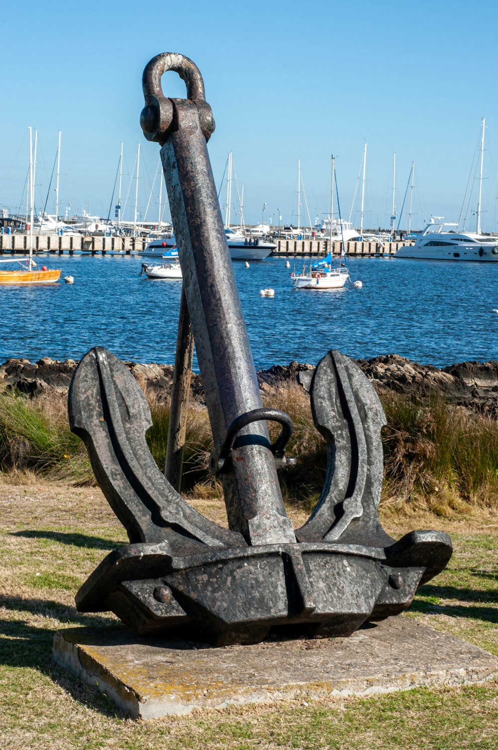 a statue of an anchor in a harbor