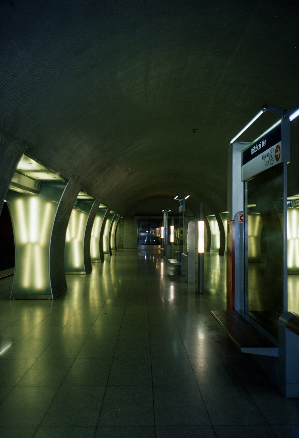 an empty subway station with lights on the walls