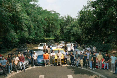 A vibrant photo of a group of Korembi members standing proudly beside their rental cars on a sunny day.