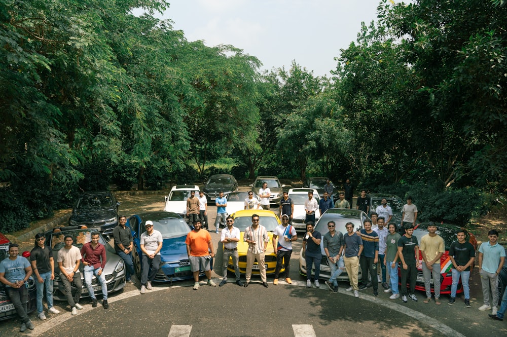a group of people standing in front of parked cars