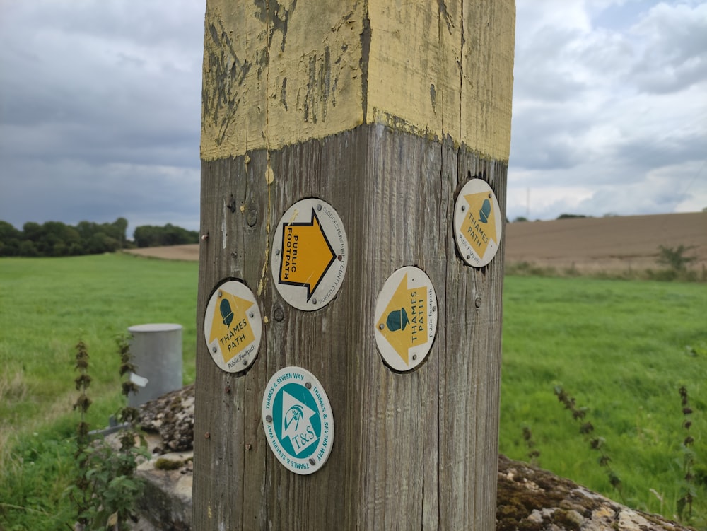 a wooden post with several stickers on it