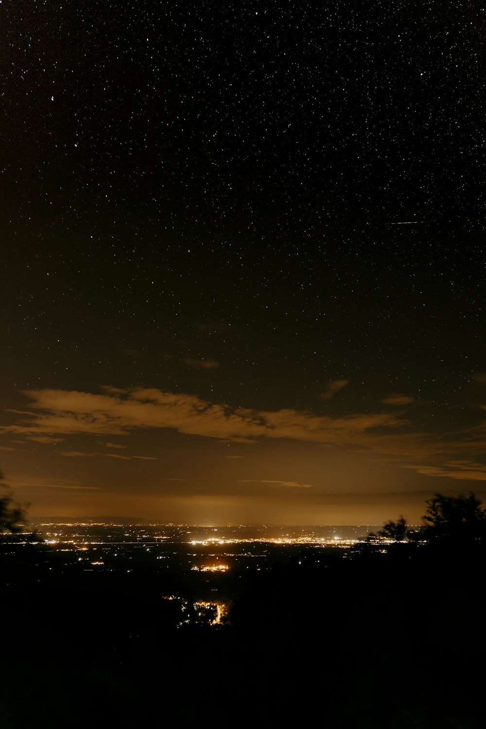 the night sky with stars above a city