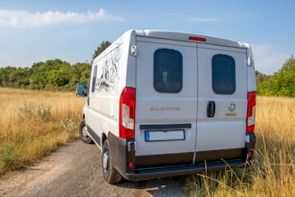 A sleek white van parked at Detling Aerodrome Estate under a clear blue sky.