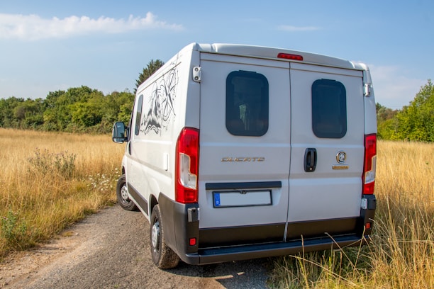 A sleek white van parked at Detling Aerodrome Estate under a clear blue sky.