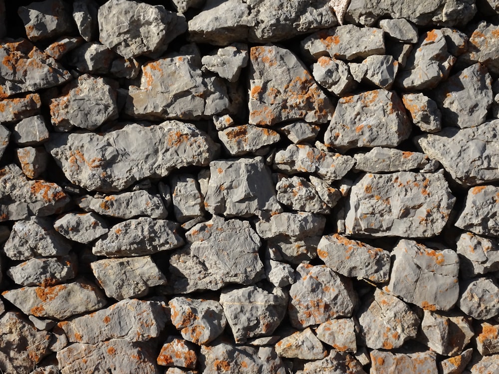 a wall made of rocks with rust on them